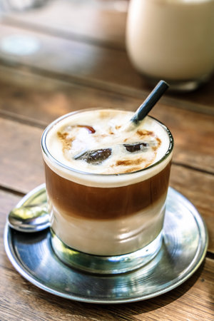 Cold coffe latte with milk in glass on city cafe table. Summer ice drinksの写真素材