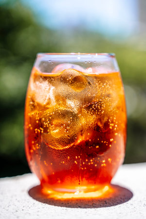 Cold cocktail. Summer soft drink with ice based on orange juice and syrup in a glass.