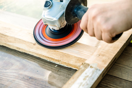 Carpenter works with wood in the workshop. Small business, production, craft concept.