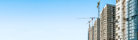 Construction Building site banner background. Construction crane with new apartment skyscraper...