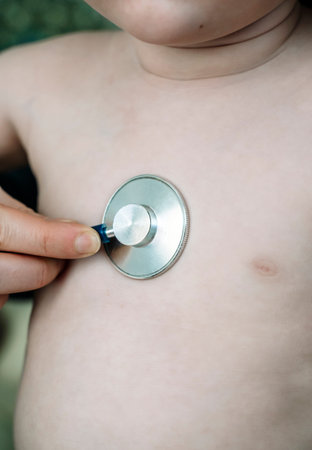 A pediatrician listens to a baby with a stethoscope in the clinic. Childrens health and care