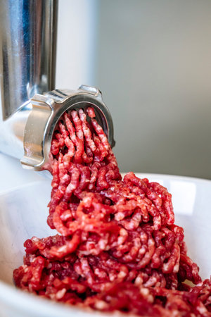 Minced meat and electric meat grinder. Cooking beef minced in the kitchen with an electric grinder