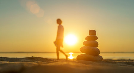 Zen stones background. Pyramid of stones on the background of sunset on the sea beach. Relax, balance, calm, concept.の写真素材