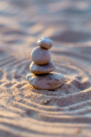 Zen stones background. Pyramid of stones on the background of sunset on the sea beach. Relax, balance, calm, concept.の写真素材
