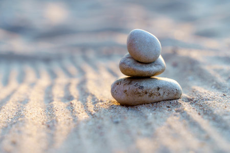 Zen stones background. Pyramid of stones on the background of sunset on the sea beach. Relax, balance, calm, concept.の写真素材