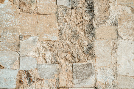 Antique ancient stone wall masonry texture background. Old wall made of beige stone blocks