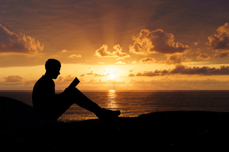 Man Reading a Book at Sunset. Knowledge and Reflection