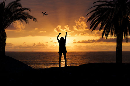 Joyful Silhouette of Woman at Tropical Sunset. Freedom and Summer Vibes
