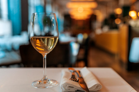 Glass of White Wine on Restaurant Table. Elegant Dining Atmosphereの写真素材