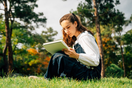 Girl Drawing in Summer Park. Relax lifestyle portraitの写真素材