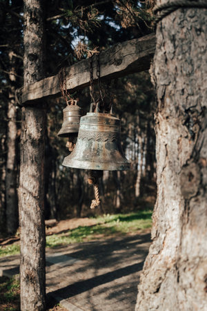 Ancient Mountain Monastery Bells Hanging Quietly Among Forest Pines at Dawnの写真素材