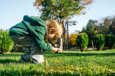 Child Learning Photography with Camera in Natureの写真素材
