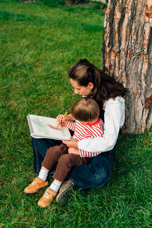 Mother and Toddler Drawing Together in a Summer Park. Parenting and Childhood Development Conceptの写真素材