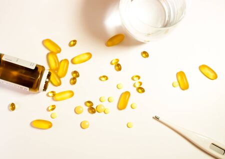 Colorful tablets and dietary supplement cod liver oil with capsules and with panels drug spilling out of a bottle, healthcare and medicine medication cureの写真素材