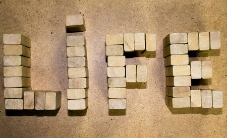 selective focus photo of The words love is god made with block wooden letters on wooden background. religion concept. vintage filtered and tonedの写真素材