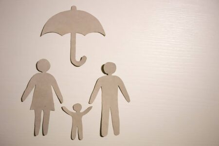 Happy paper family with house on dark vintage wooden backgroundの写真素材