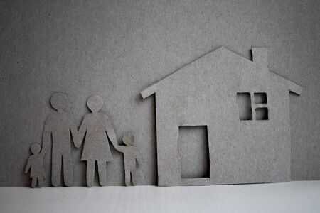 Happy paper family with house on dark vintage wooden backgroundの写真素材