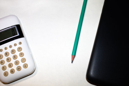 Flat lay, top view office table desk. Workspace with calculator, black pen , laptop on the indigo...