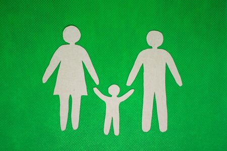 Paper cut family silhouette in a cardboard hand on cardboard background.の写真素材