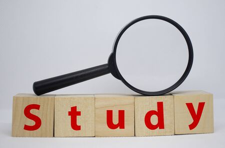 Inscription Study, lined with cubes. A look through a magnifying glass. Golden background. Reflection. Abstraction and symbolismの写真素材