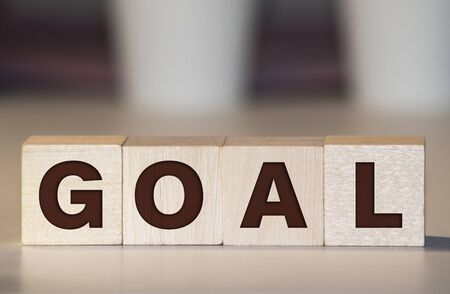 Businessman puts wooden blocks with the word Goal. The concept of achieving business goals.の写真素材