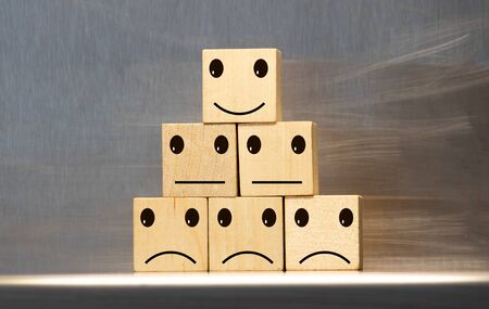Customer chooses a smiley face on wood cube block, Business service rating , Satisfaction conceptの写真素材