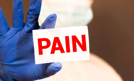 Pain card in hand of Medical Doctor. Healthcare pain relief concept.の写真素材