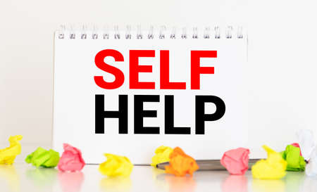 Black book with the words self-help title on front. Isolated on white with path.の写真素材