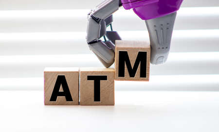 Wooden cubes with word ATM, credit cards and coins on table.の写真素材