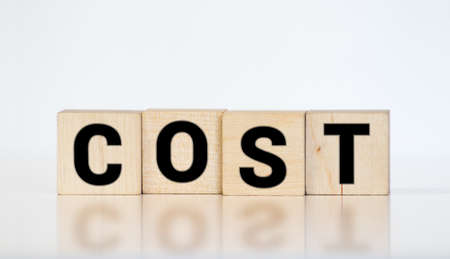 Cost, expense or company profit and loss concept, cube wooden block with alphabet combine word COST on white grid paper, analyze spending or payment.の写真素材