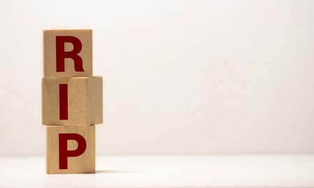 Rest in peace. Wood block RIP with old Plumeria flower and light on black table. Sadness. End of life. Can be use for card, brochure, web.の写真素材