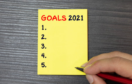 goal 2021 Top view flat lay of desktop and notepads writing down goals and plans.