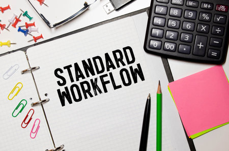 STANDARDS man hand notebook and other office equipment such as computer keyboard.