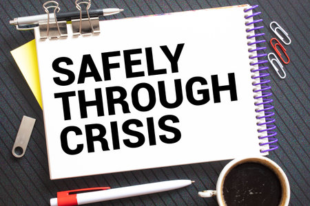magnifier and paper with documents and SAFELY THROUGH CRISIS.