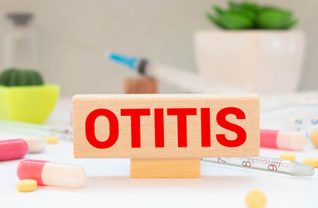 top view blocks with word OTITIS on the white background with pills.