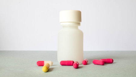 Pink pills spilling from a bottle