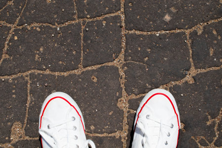 White Sneaker shoes standing on street. Top view. Vintage effect