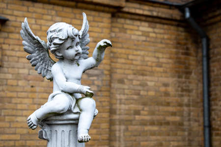 figure of an angel on the background of a brick building.の写真素材