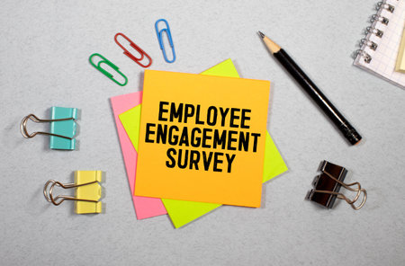 Employee Engagement Survey sign written on sticky note pinned on wooden wall