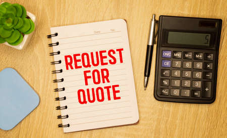 a business card with the inscription - FREE ESTIMATES on a wooden table next to a pen and a calculator, business concept.の写真素材