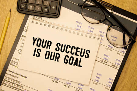 Your Success Is Our Goal notepad writing concept on dark background with pen.の写真素材