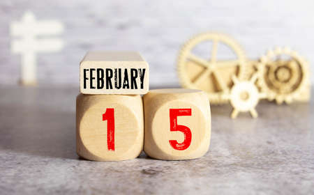 Calendar reminder event concept. Wooden cubes with numbers and month on February 15 with sunlight.の写真素材