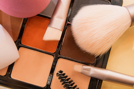 Flat lay composition with makeup brushes on violet background, space for text