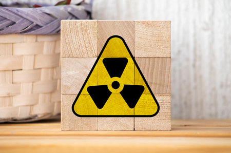 Radioactive ionizing radiation round yellow and black danger symbol painted on a massive rusty metal wall with dark rustic grunge texture background. Nuclear, radioactive alert concept.の写真素材