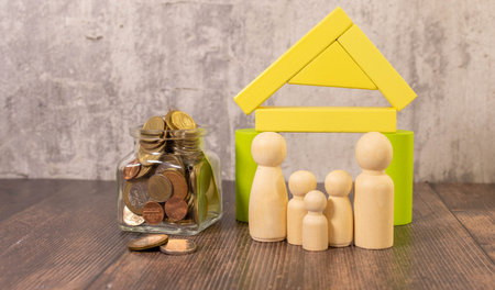 Home and money bag put on the scales with balance put on the wood in the public park, Saving for buy...