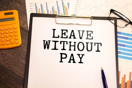 Closeup on businessman holding a card with text LEAVE WITHOUT PAY, business conceptの写真素材