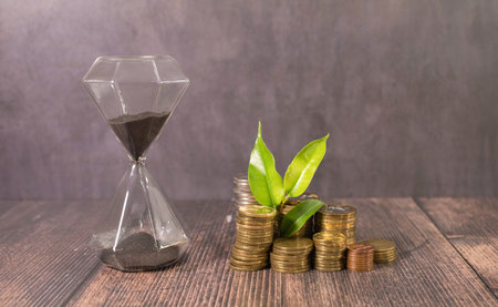 The saplings that grow on the pile of coins include the white light flooding the trees, business ideas, saving money, and economic growth.の写真素材