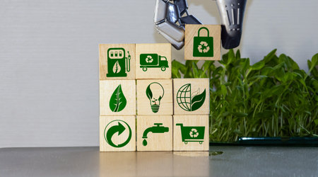 Crop person arranging small wooden blocks together to compose recycle emblem with eco friendly imagesの写真素材