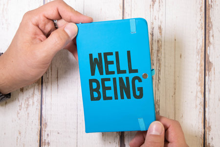 Business card with the text WELL BEING on a wooden table. Brown diary and pen. Business conceptの写真素材