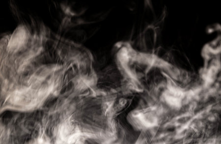 Billowing cloud of white smoke against dark background.の写真素材